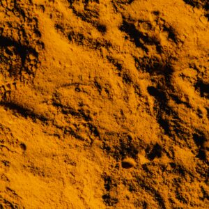 A detailed close-up of vibrant yellow turmeric powder showing its textured surface.