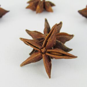 Close-up of star anise on white surface, ideal for culinary themes.