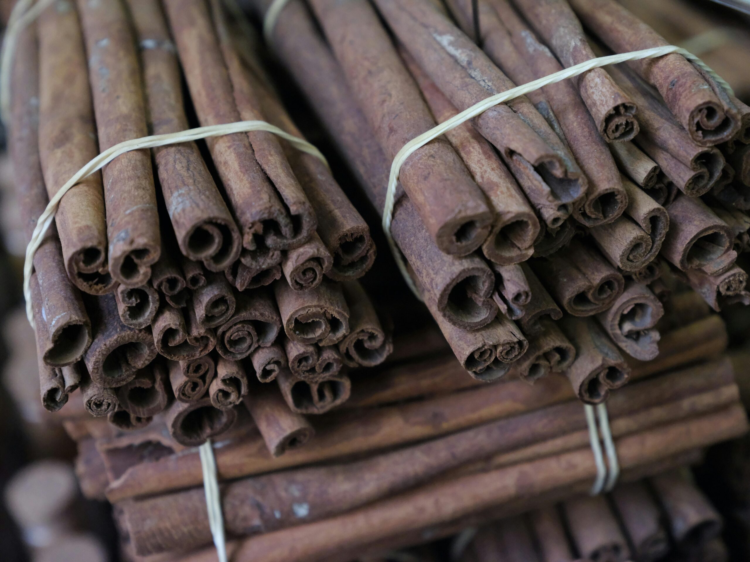 Close-up of cinnamon sticks bundled together, showcasing texture and spice aroma.