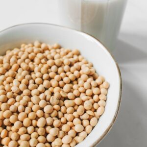 Close-up of soybeans in a bowl with a glass of soy milk. Perfect for healthy living concepts.