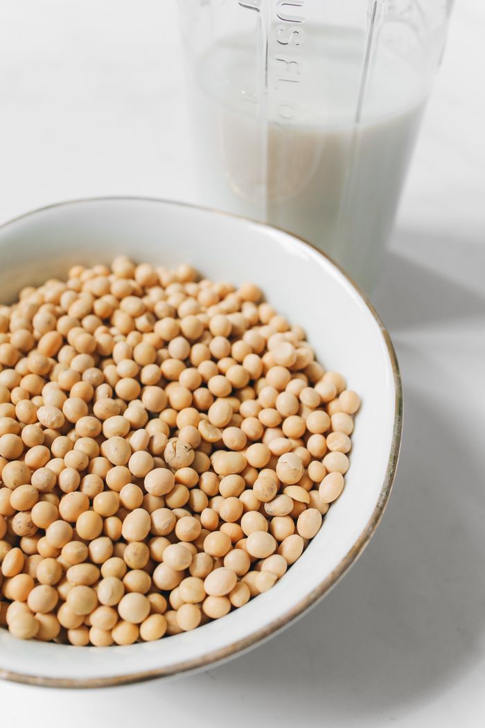 Close-up of soybeans in a bowl with a glass of soy milk. Perfect for healthy living concepts.